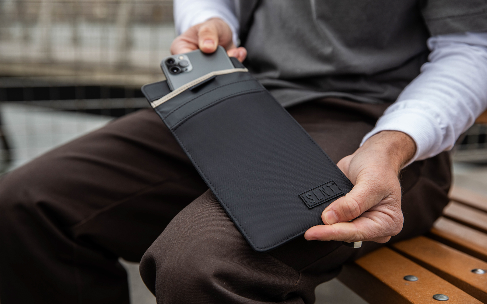 Man slipping his phone into a Faraday Phone Sleeve