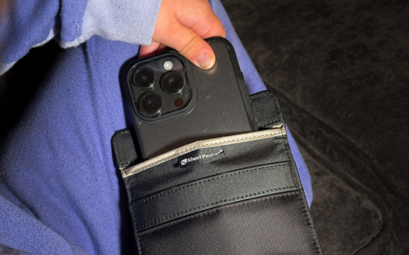 kids hand with slnt faraday sleeve and phone