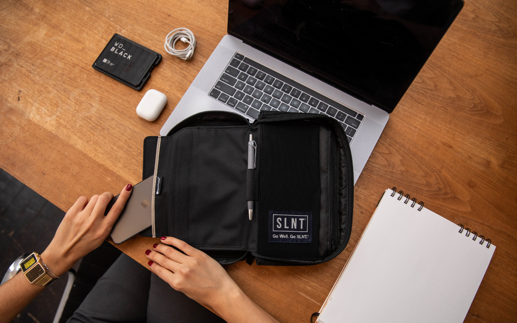 a phone being placed inside a SLNT Faraday cage organizer