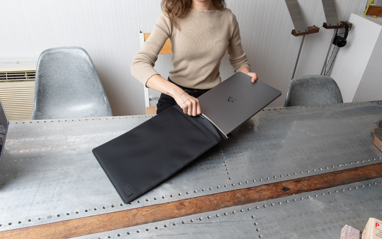 Women placing laptop into Faraday sleeve