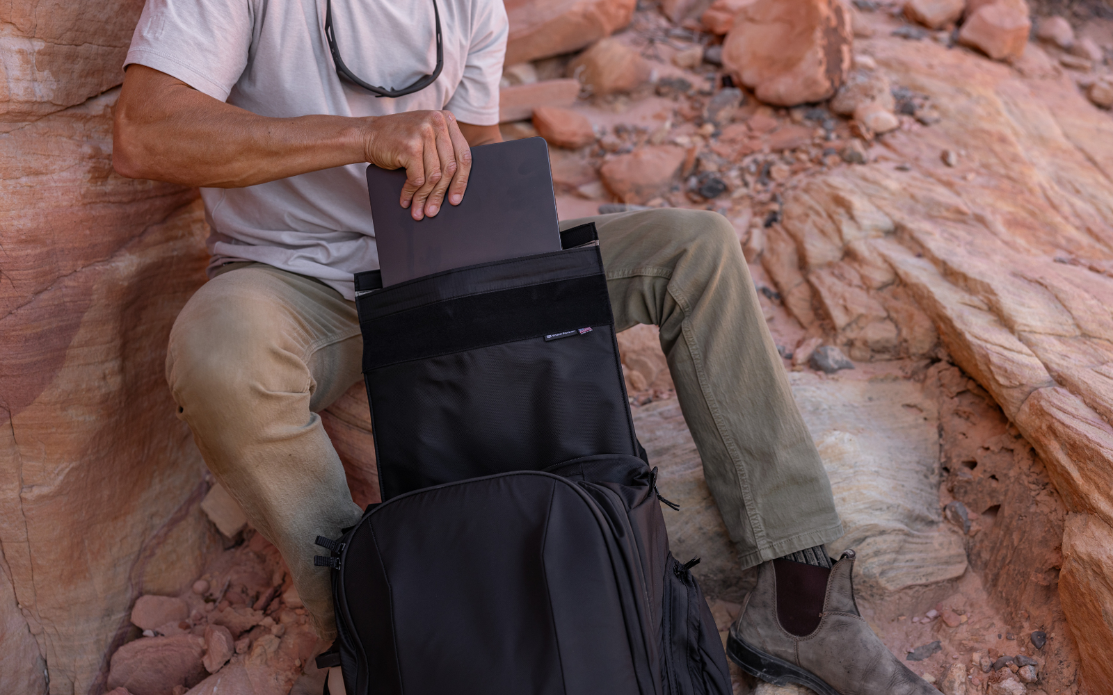 Man placing laptop into a USA made Faraday Backpack