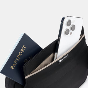 A passport and smartphone stored inside the Faraday bag’s signal-blocking compartment.