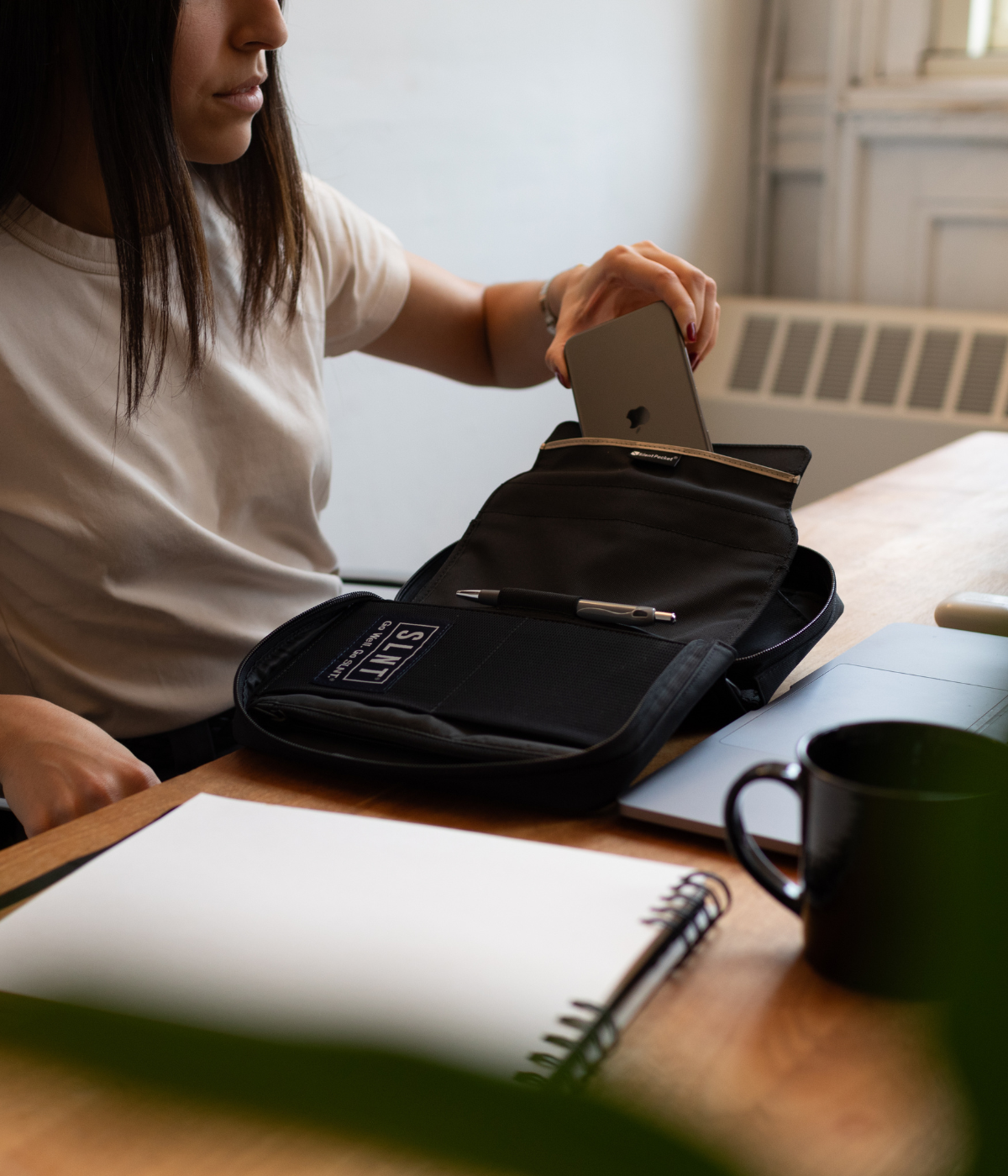 Women putting a phone in a Faraday tech organizer