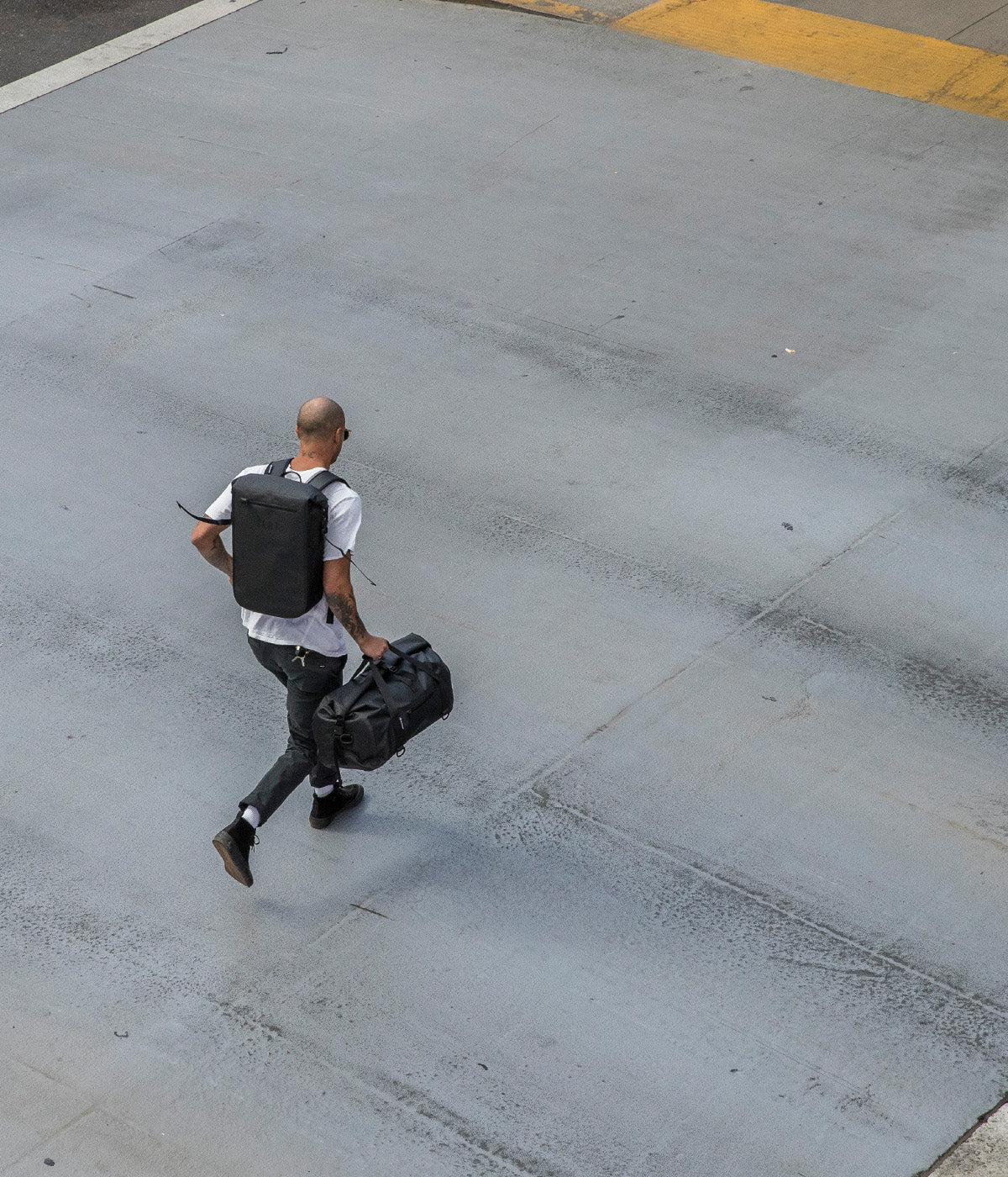 man carrying faraday backpack and a duffle bag